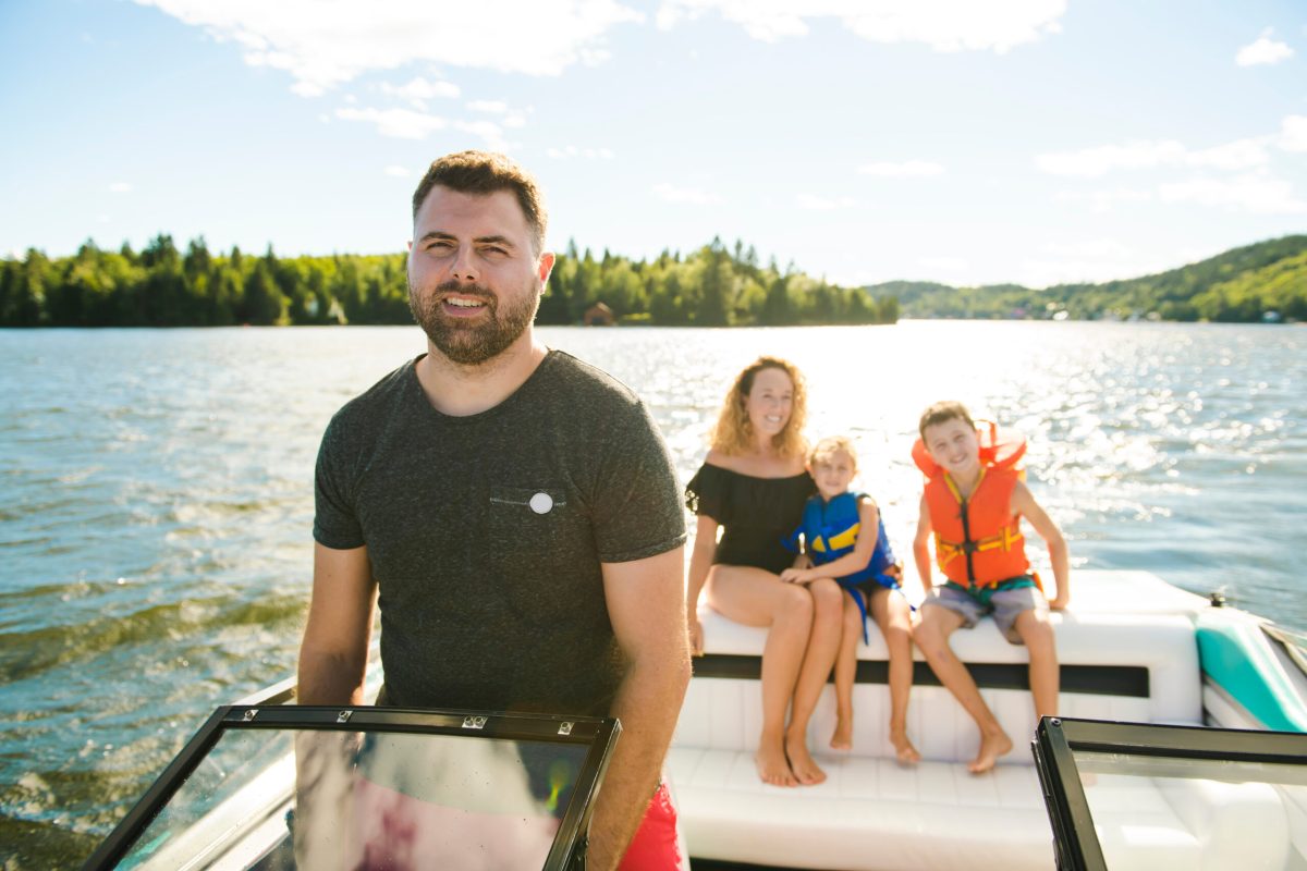 Man driving boat on holiday with his son kids and his wife a man in a boat on a body of water