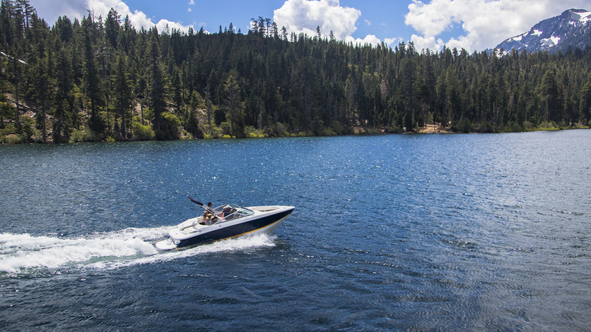 a small boat in a body of water with a mountain in the background