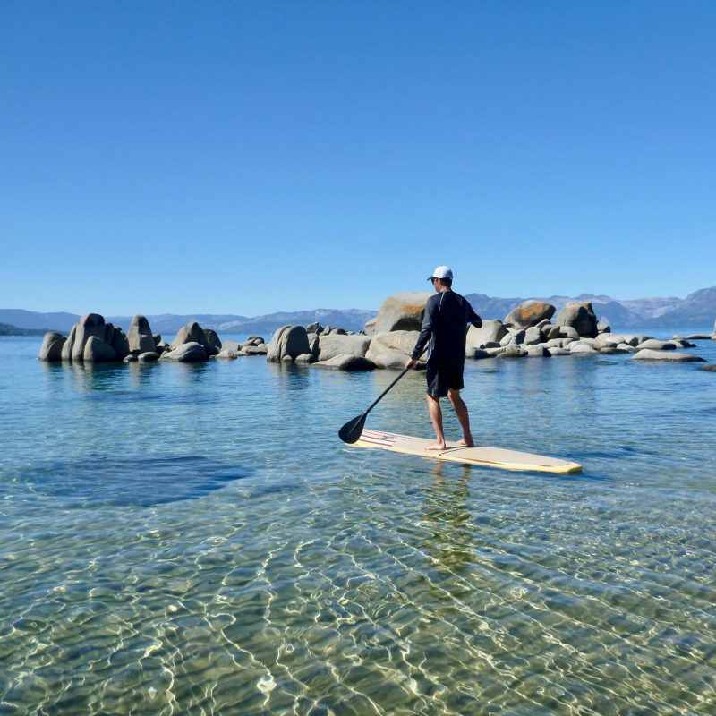 a group of people standing next to a body of water