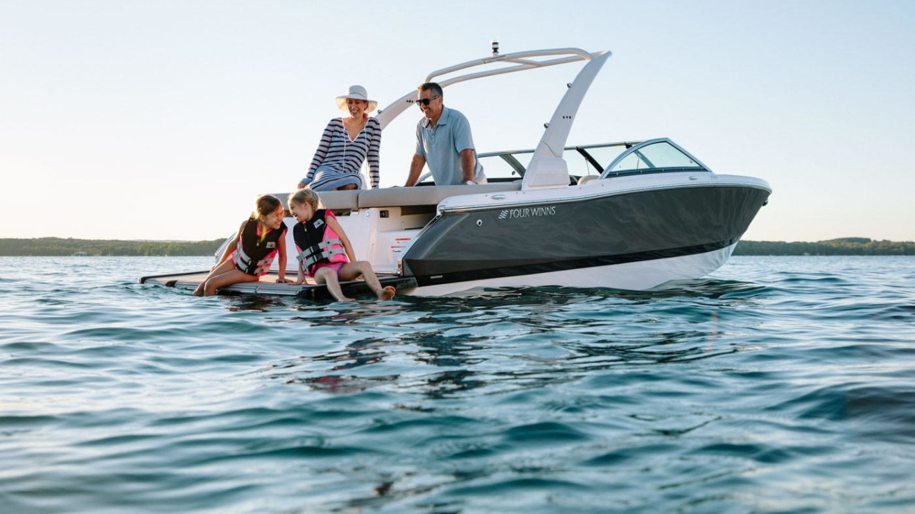 a man riding on the back of a boat in the water