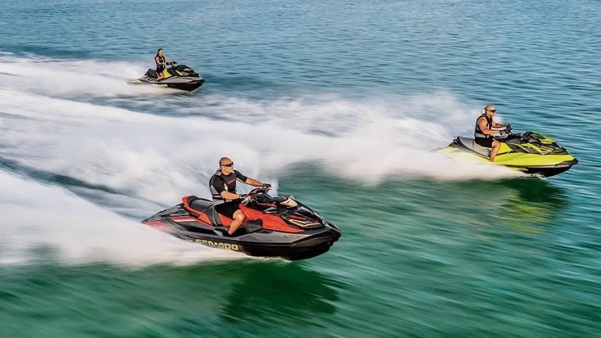 a group of people riding on the back of a boat in the water