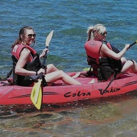 a person riding on the back of a boat on a body of water