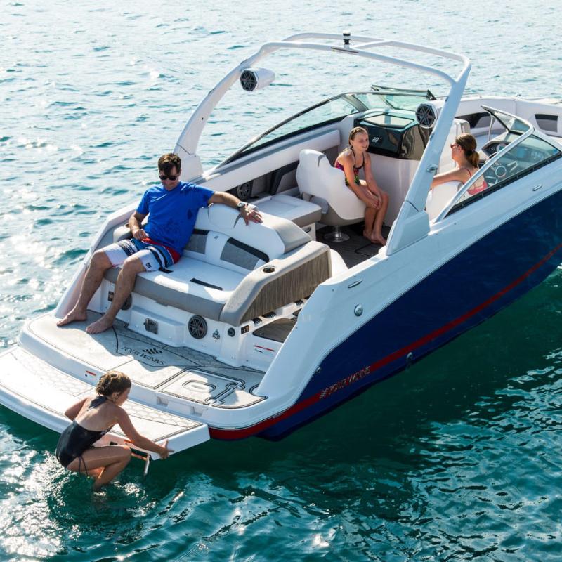a group of people riding on the back of a boat in the water