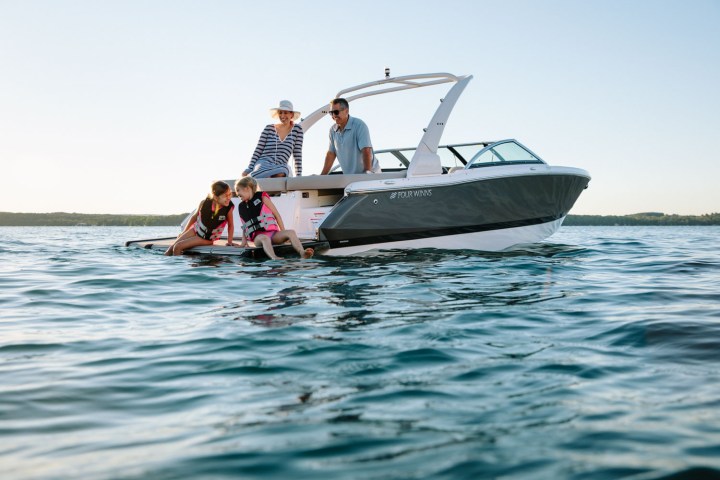 a man riding on the back of a boat in the water