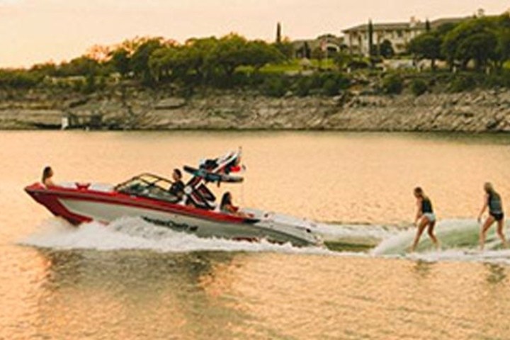 a group of people riding on the back of a boat in the water