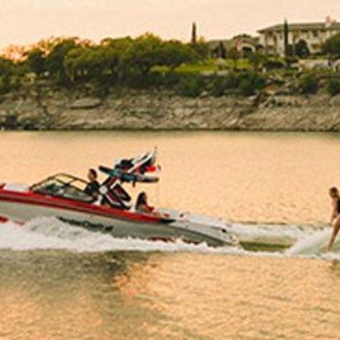 a group of people riding on the back of a boat in the water