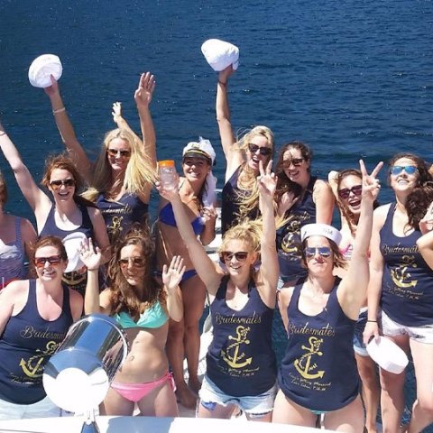 a group of people posing in front of a body of water
