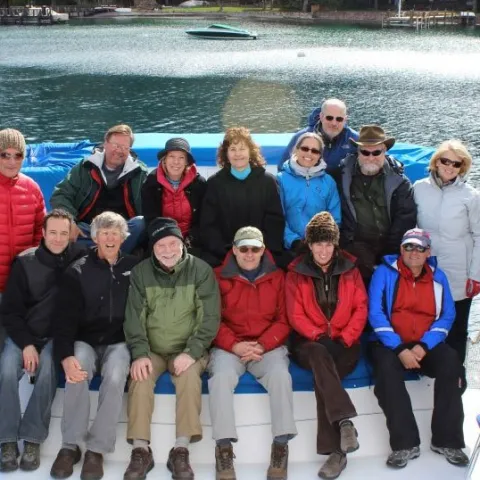 a group of people posing in front of a body of water